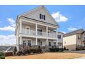 Charming two-story home with a two-car garage, a double stacked front porch, and landscaped front yard at 3418 Longleaf Estates Dr, Raleigh, NC 27616
