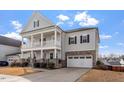 Charming two-story home with a two-car garage, a double stacked front porch, and landscaped front yard at 3418 Longleaf Estates Dr, Raleigh, NC 27616
