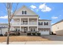 Charming two-story home with a two-car garage, a double stacked front porch, and landscaped front yard at 3418 Longleaf Estates Dr, Raleigh, NC 27616