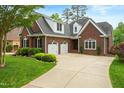 Attractive brick home with a spacious driveway, well-kept lawn, and lush landscaping at 498 Mountain Laurel, Chapel Hill, NC 27517