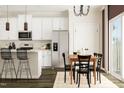 Modern kitchen with stainless steel appliances, white cabinets, and a dining area at 5322 River Reach Dr, Raleigh, NC 27616
