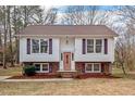 Charming two-story home with white siding, brick foundation, dormers, and a welcoming front porch at 7 Harrigan Ct, Durham, NC 27705