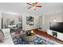 Inviting living room with hardwood floors, a stylish rug, and views into the kitchen and dining area at 7 Harrigan Ct, Durham, NC 27705