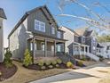 Two-story home with a cozy front porch, manicured lawn, and contemporary design elements at 705 Vine Pkwy, Pittsboro, NC 27312