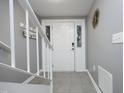 Bright foyer with tile floors, a white front door and staircase at 7736 Falcon Rest Cir, Raleigh, NC 27615