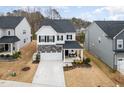 A high angle showcases this home's manicured lawn, ample driveway, and quaint covered porch at 824 Wrights Creek Way, Wake Forest, NC 27587