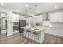 A bright kitchen features a large center island, stainless steel appliances, and modern pendant lighting at 824 Wrights Creek Way, Wake Forest, NC 27587