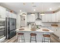 Island kitchen with white cabinets, quartz countertop, pendant lights, and stainless steel appliances at 824 Wrights Creek Way, Wake Forest, NC 27587