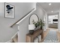 Stylish entryway featuring a wooden table, plants, and a large round mirror at 90 Rigsby Ave, Four Oaks, NC 27524