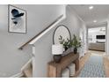 Inviting hallway features a wooden console table, round mirror, and stylish runner leading to the living room at 90 Rigsby Ave, Four Oaks, NC 27524