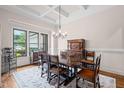 Elegant dining room featuring a coffered ceiling, chandelier, and traditional furniture set at 946 Berry Patch Ln, Pittsboro, NC 27312
