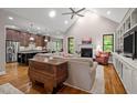 Open-concept space with kitchen view, hardwood floors, fireplace, and vaulted ceiling at 946 Berry Patch Ln, Pittsboro, NC 27312