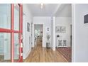 Bright foyer with hardwood floors, a red front door, white trim, and an entry table with decorative rug at 1012 Addison Pl, Raleigh, NC 27610