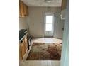 Outdated kitchen with wood cabinets, laminate counters, and a worn floor rug at 1117 S Blount St, Raleigh, NC 27601
