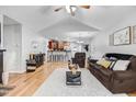 Open-concept living room with hardwood floors, vaulted ceiling, and seamless flow into the kitchen area at 112 E Main St, Micro, NC 27555