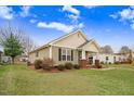 Charming home exterior displaying manicured lawn, complemented by well-placed shrubbery and timeless architectural details at 112 E Main St, Micro, NC 27555