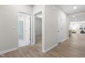 Bright hallway with hardwood floors leads to a bathroom, bedroom, and open living space at 120 Longspur Ln, Rolesville, NC 27571