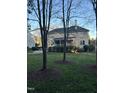 Backyard view with large lawn, patio, porch, mature trees, and privacy fencing at 12321 Penrose Trl, Raleigh, NC 27614