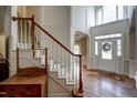 Bright foyer with hardwood floors, staircase, and a decorative front door with transom windows at 12321 Penrose Trl, Raleigh, NC 27614