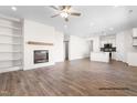 Spacious living room featuring a fireplace, built-in shelving, wood-look flooring, and open to the kitchen at 130 W Saltgrass Ln, Smithfield, NC 27577