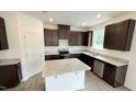 Modern kitchen featuring dark cabinetry, granite countertops, and stainless steel appliances at 140 Gobbler Dr, Smithfield, NC 27577