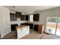 Unfinished kitchen featuring dark wood cabinets and an island, ready for personalization at 140 Gobbler Dr, Smithfield, NC 27577