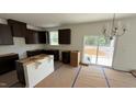 Open-concept kitchen with dark wood cabinets and a modern chandelier, offering room for customization at 140 Gobbler Dr, Smithfield, NC 27577