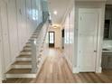 Bright foyer featuring hardwood floors, paneled walls, and a staircase leading to the upper level at 1405 Song Bird Crest Way, Raleigh, NC 27613