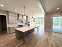 Gourmet kitchen with a large island, custom cabinetry, stainless appliances and hardwood flooring at 1405 Song Bird Crest Way, Raleigh, NC 27613