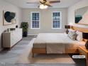 Bright bedroom featuring a ceiling fan, a light wood bed frame, and two windows that let in plenty of natural light at 143 George Wilton Dr, Clayton, NC 27520