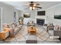 Elegant living room featuring a fireplace, ceiling fan, and stylish decor, virtually staged for inspiration at 143 George Wilton Dr, Clayton, NC 27520