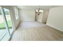 Open concept space features a dining area with modern chandelier, sliding doors, and carpeted living room at 158 Gobbler Dr, Smithfield, NC 27577