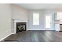 Cozy living room with a fireplace, hardwood floors, and access to the backyard at 183 W Saltgrass Ln, Smithfield, NC 27577