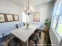Dining room with a modern chandelier, rustic wall art, and a view of the backyard at 189 W Saltgrass Ln, Smithfield, NC 27577