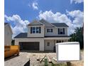 Two-story home featuring a two-car garage and classic black shutters, set against a bright sky at 189 W Saltgrass Ln, Smithfield, NC 27577