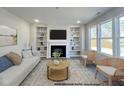 Living room with built-in shelving, a fireplace, a patterned rug, and large windows at 189 W Saltgrass Ln, Smithfield, NC 27577