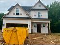 New construction home featuring black roof, framed windows, and attached garage awaiting final finishes at 197 W Saltgrass Ln, Smithfield, NC 27577