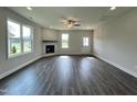 Spacious living room with hardwood floors, a fireplace, and big windows showcasing a neighborhood view at 201 W Saltgrass Ln, Smithfield, NC 27577