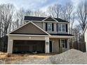 New construction home featuring a two-car garage and a classic two-story design with black shutters at 211 W Saltgrass Ln, Smithfield, NC 27577