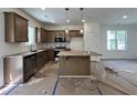 New kitchen featuring an island with stone countertops, a microwave, and updated appliances at 211 W Saltgrass Ln, Smithfield, NC 27577