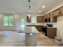 Modern kitchen featuring stainless steel appliances, granite countertops, wood cabinets, and an island at 211 W Saltgrass Ln, Smithfield, NC 27577