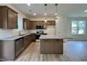 Modern kitchen with stainless steel appliances, granite countertops, wood cabinets and a center island at 211 W Saltgrass Ln, Smithfield, NC 27577