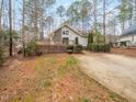 Welcoming home with a stone chimney, spacious deck, and manicured landscaping, surrounded by mature trees at 228 Sagamore Dr, Louisburg, NC 27549