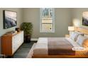 Cozy bedroom with hardwood floors, comfortable bed, and a picturesque view from the window at 2412 Little John Rd, Raleigh, NC 27610
