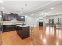 Open-concept kitchen with a granite-topped island, stainless appliances, and wood floors overlooking the living area at 2459 Memory Ridge Dr, Raleigh, NC 27606
