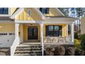 Inviting front porch with stone steps, a seating area, and classic columns at 2500 Plowridge Rd, Fuquay Varina, NC 27526