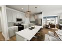 Kitchen with white cabinets, stainless steel appliances, an island, and pendant lighting at 287 Beacon Dr, Pittsboro, NC 27312