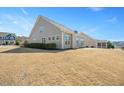 Expansive backyard featuring a well-manicured lawn, mature trees, and a covered patio at 345 Springtime Fields Ln, Wake Forest, NC 27587