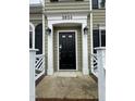 Close-up of the front door with white trim, black hardware, and decorative sconces on either side at 3624 Singleleaf Ln, Raleigh, NC 27616