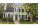 Charming two-story home with green siding, black shutters, and a well-manicured front yard at 3624 Singleleaf Ln, Raleigh, NC 27616
